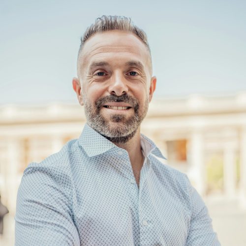 Portrait of a confident businessman outside in Paris, showcasing professional and friendly demeanor.
